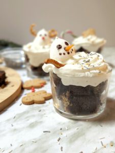 brownies de chocolate con decoración de Navidad de nata, muñeco de nieve y reno