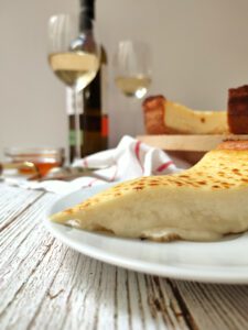 trozo de tarta de queso con copa de vino