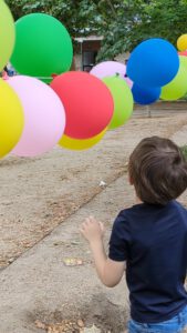 niño jugando con globos en el parque